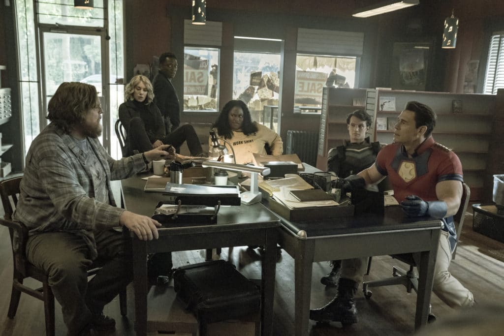 (L-R): John Economos (Steve Agee), Emilia Harcourt (Jennifer Holland), Clemson Murn (Chukwudi Iwuji), Leota Adebayo (Danielle Brooks), Adrian Chase/Vigilante (Freddie Stroma), and Christopher Miller/Peacemaker (John Cena) in DC's PEACEMAKER.