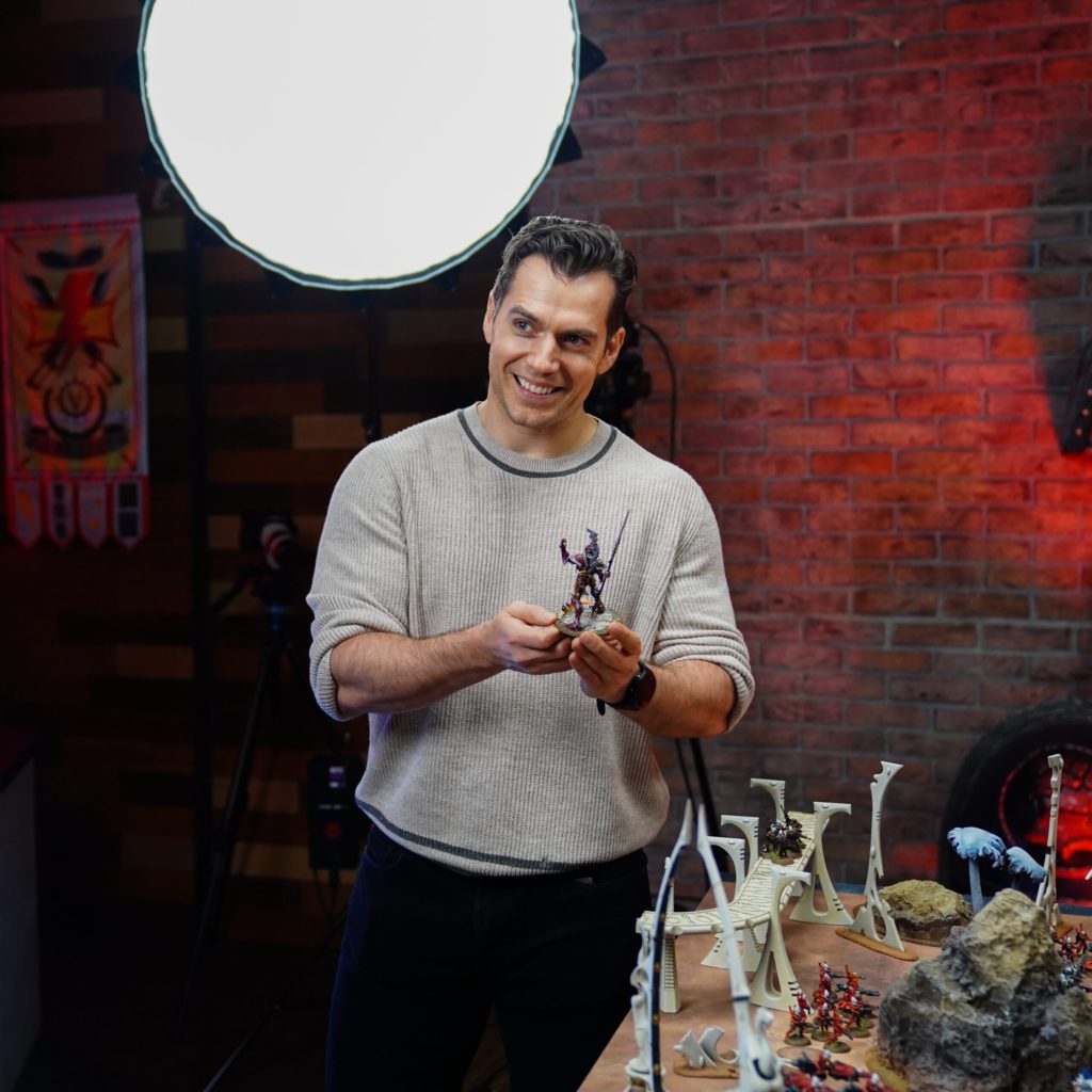 Henry Cavill holding Warhammer minifigure